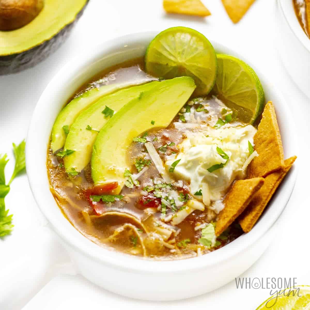 Bowl of keto chicken tortilla soup with toppings