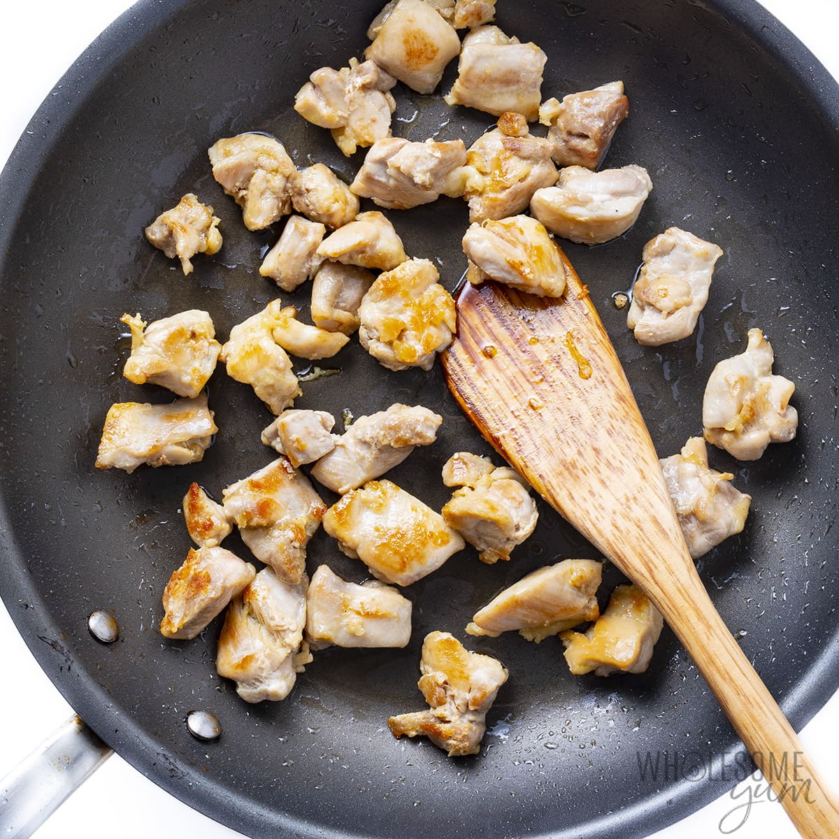 Cooked chicken pieces in a large skillet.