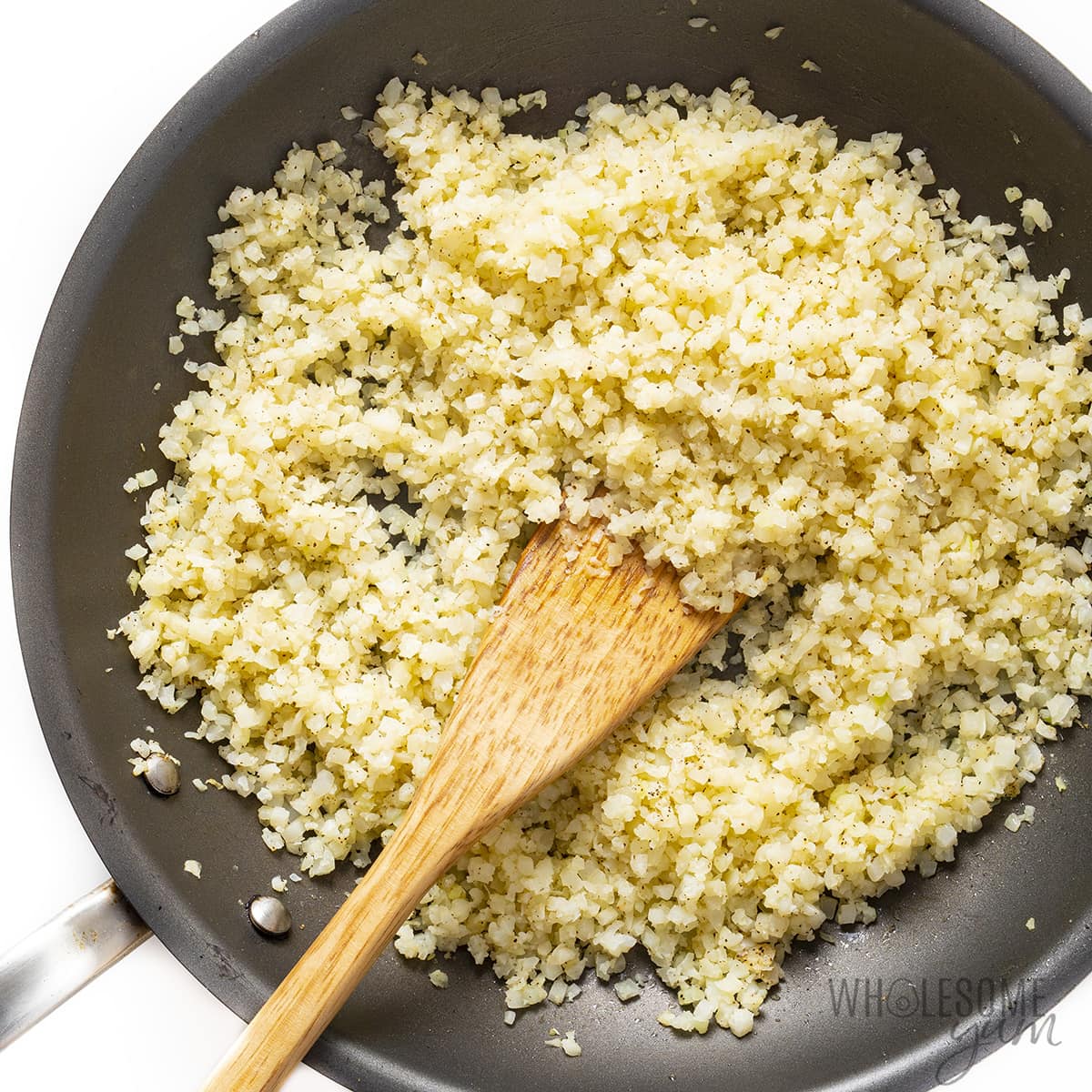Cooked cauliflower rice in a large skillet.