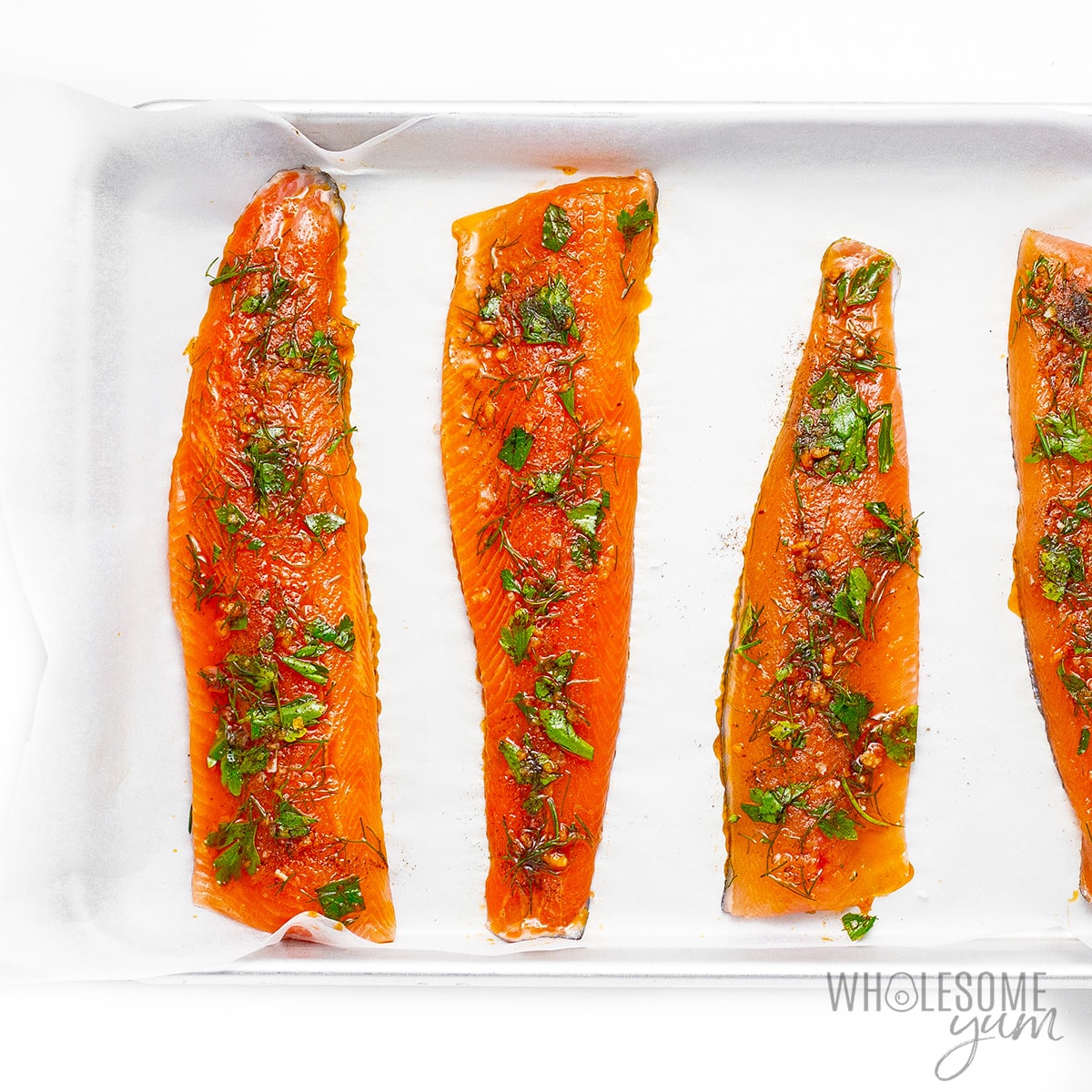 Raw rainbow trout fillets brushed with olive oil mixture.