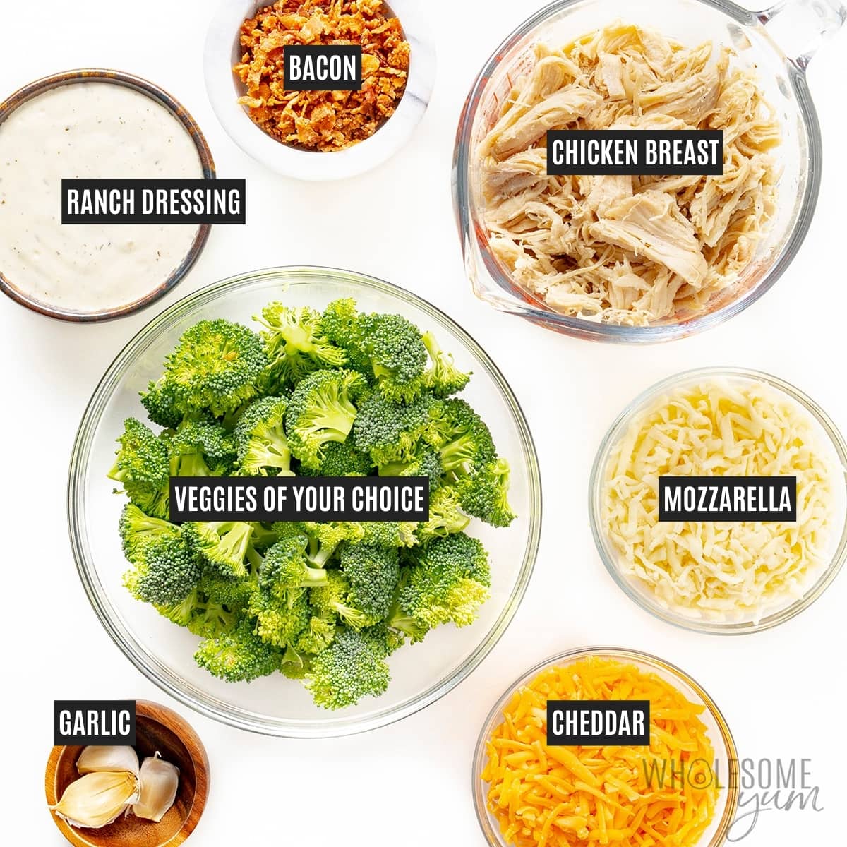 Bowls of broccoli, chicken breast, bacon, ranch, garlic, and cheeses.