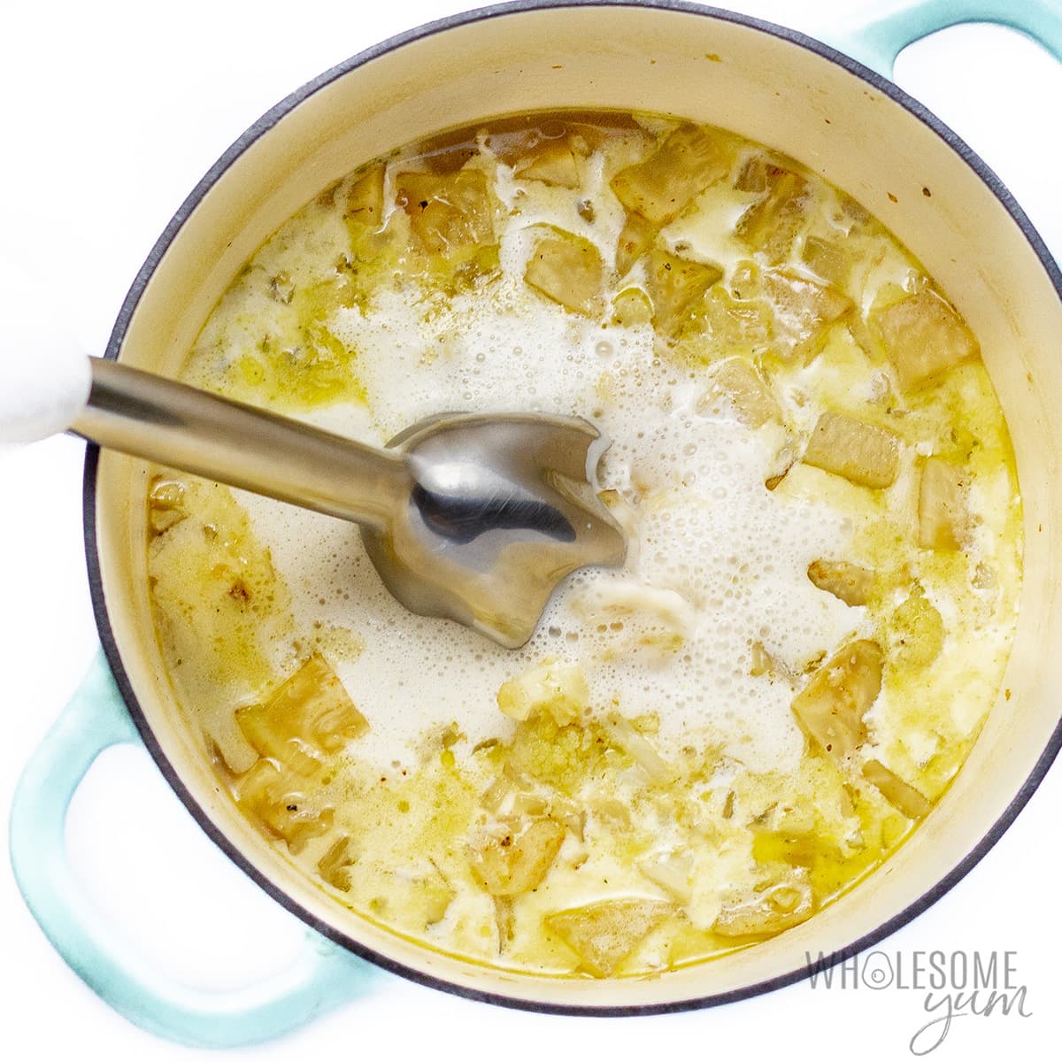 Blending celery root soup with immersion blender.