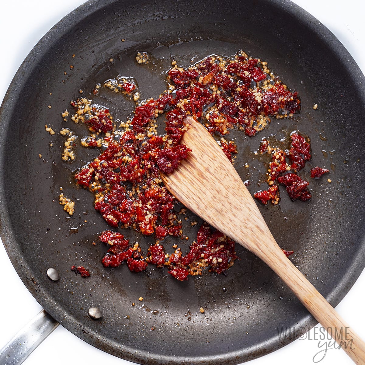 Sauteed garlic and sun-dried tomatoes in a skillet.