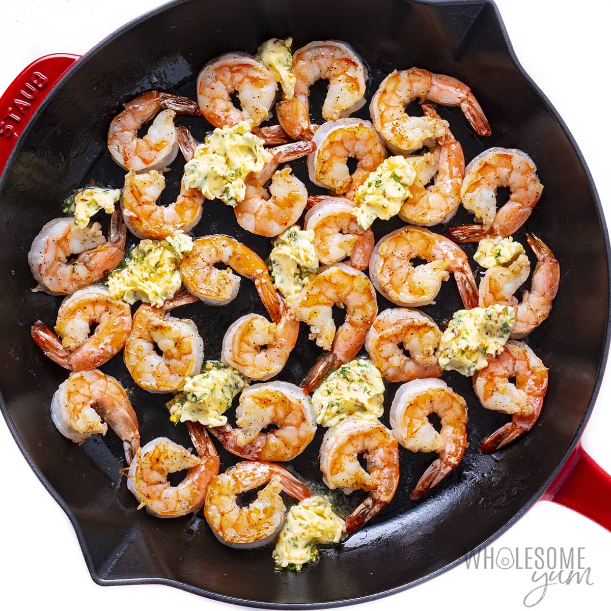 Cooked shrimp with garlic butter melting around it.