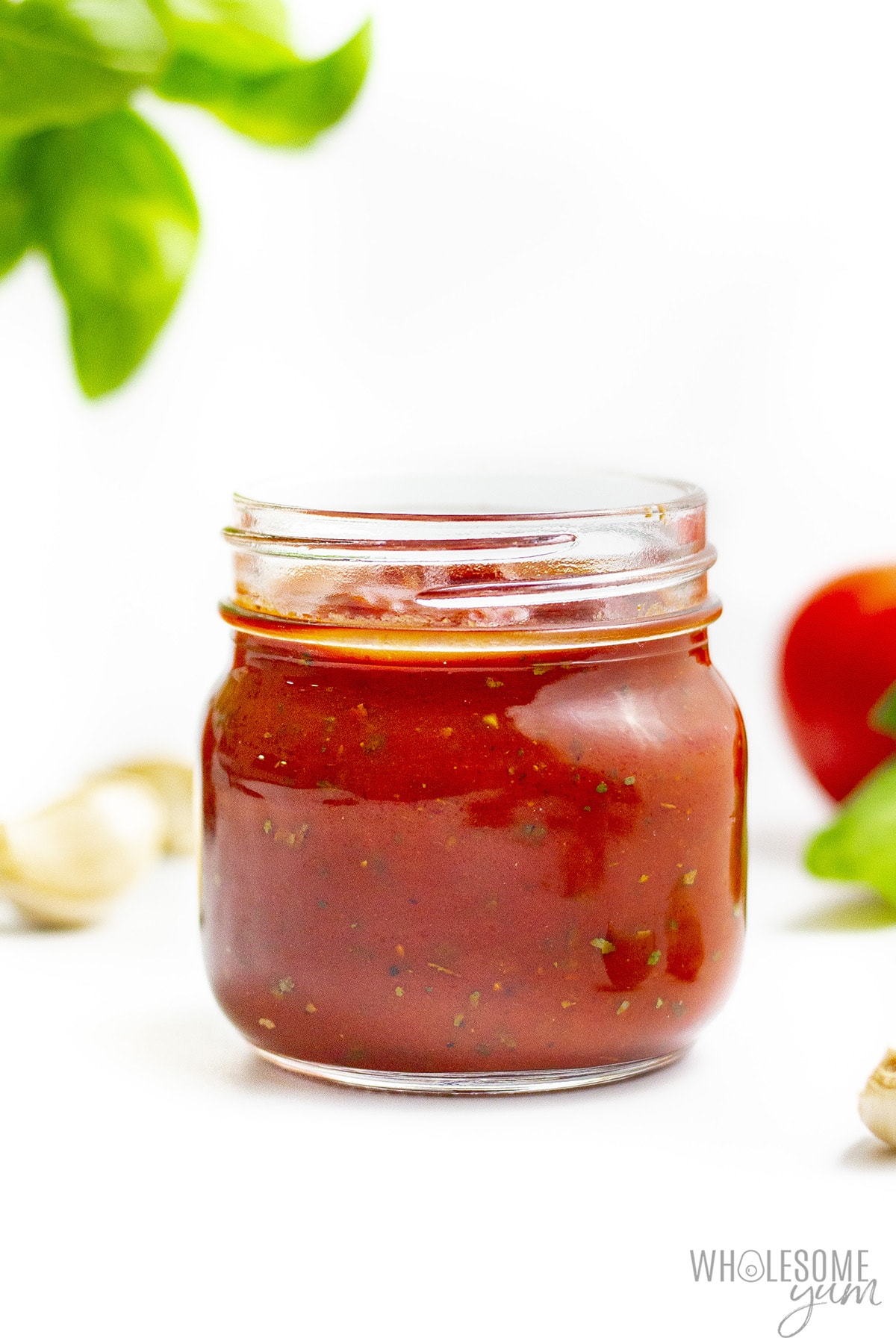 Low carb pizza sauce in a jar with ingredients in background.