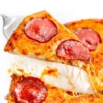 Cheese crust pizza slice with cheese pull.