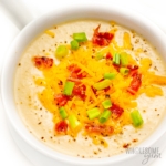 Celery root soup recipe in a bowl with toppings.