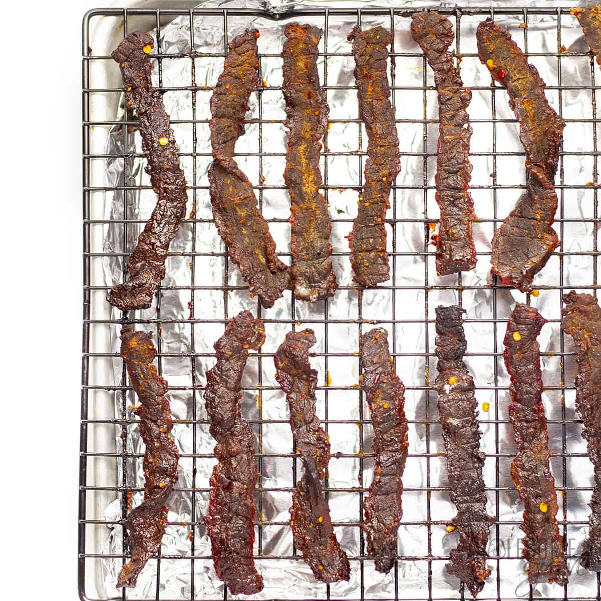 Baked homemade beef jerky on cooling rack.