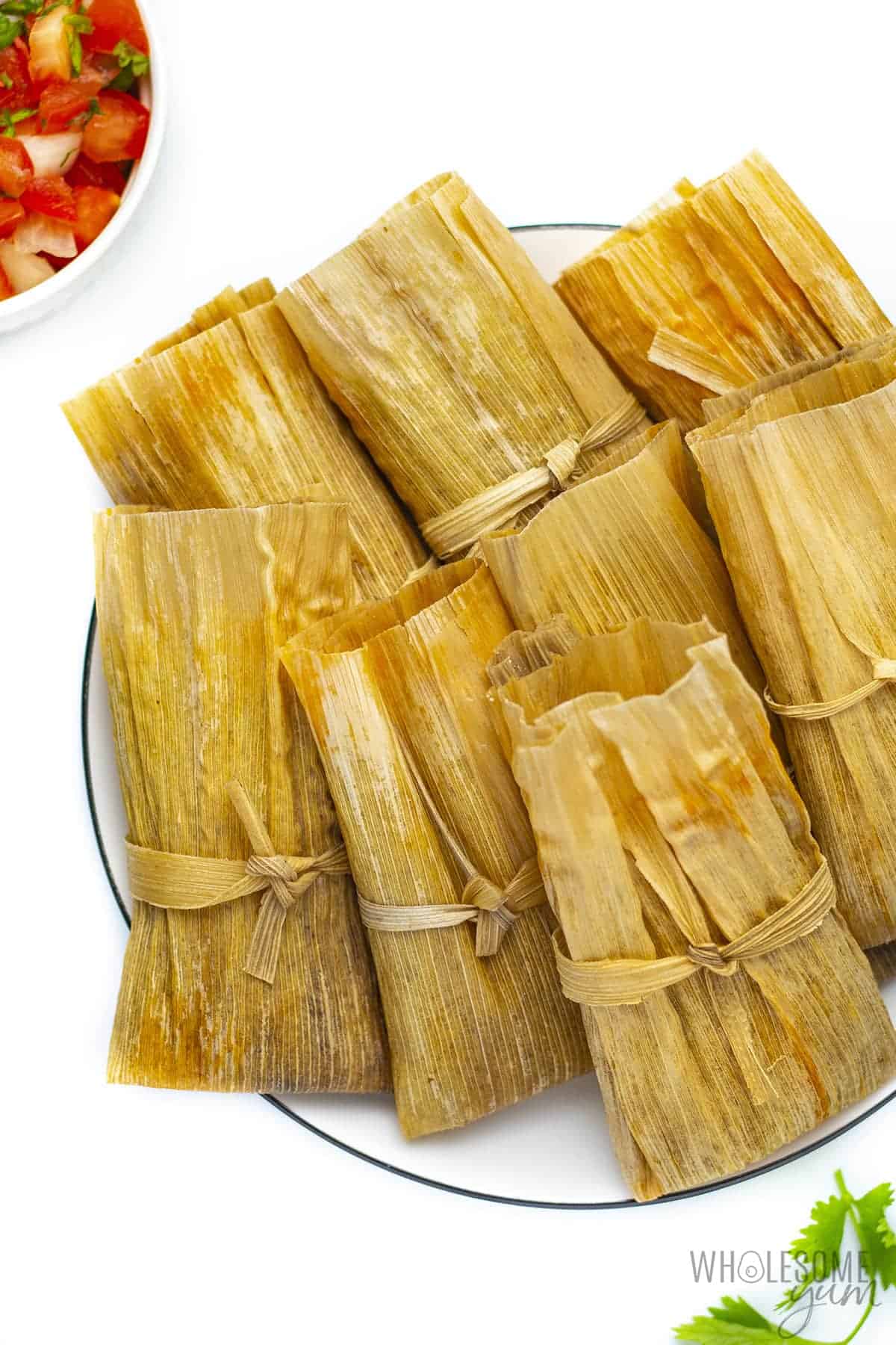 Keto friendly tamales on a plate with wrappers.