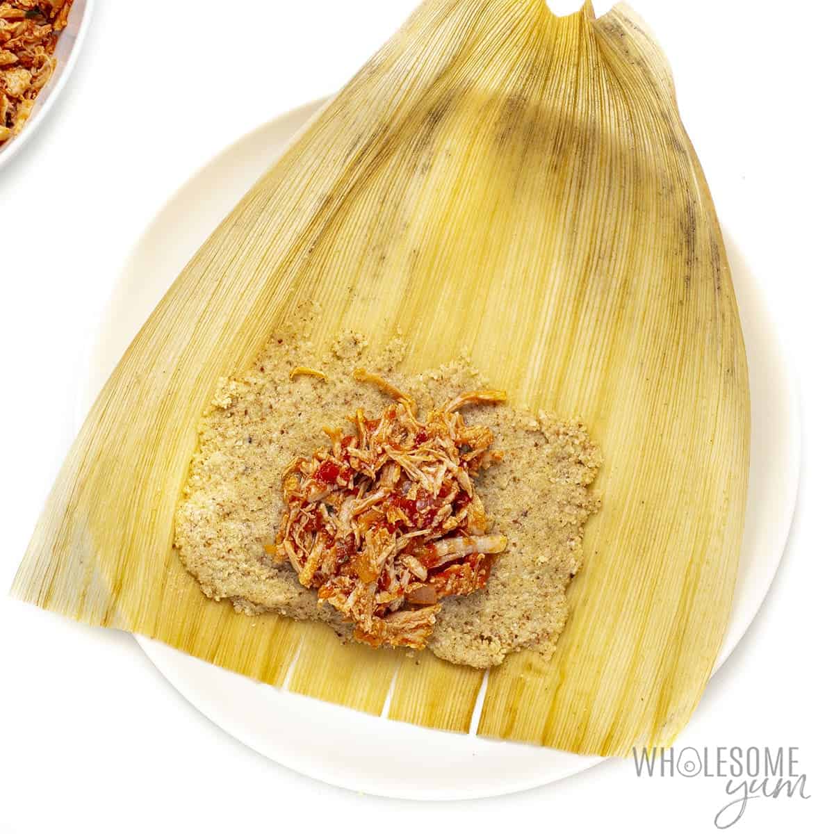 Keto tamale with chicken filling on corn husk.