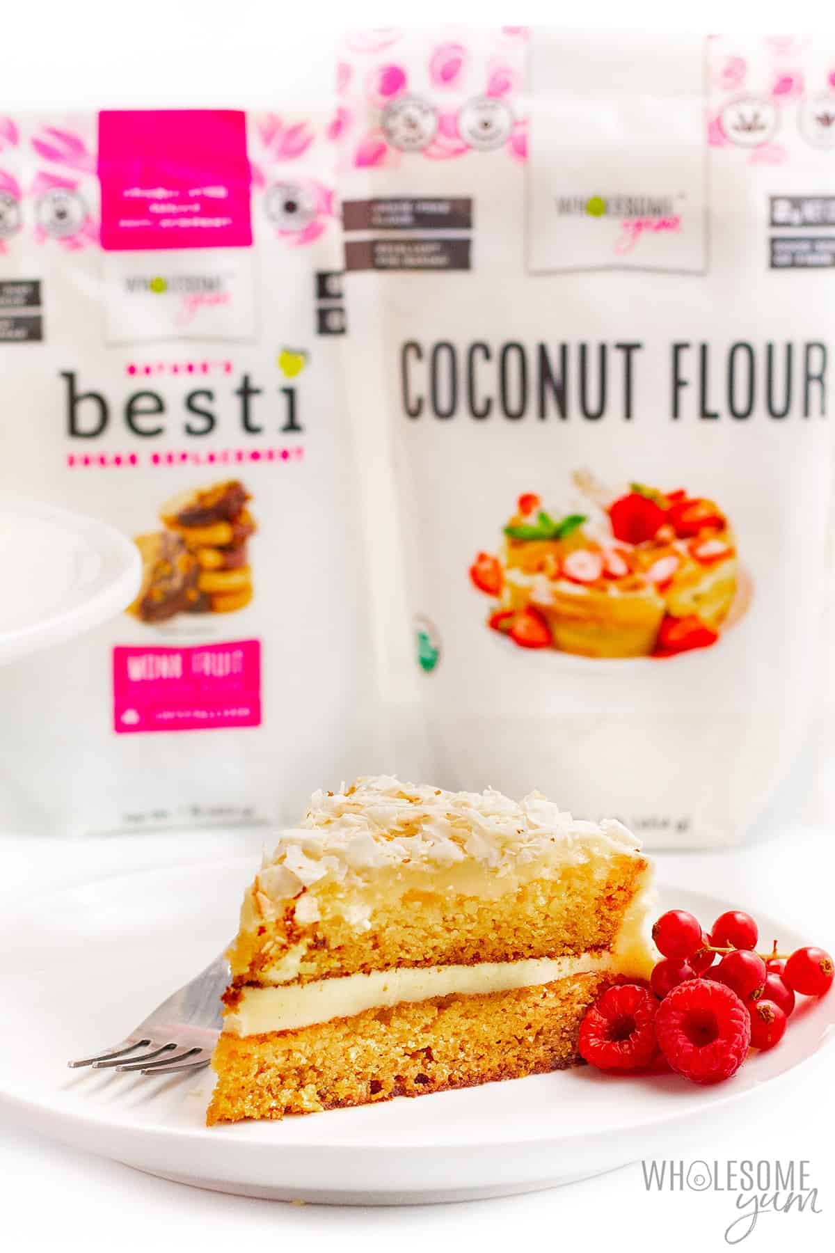 Slice of coconut cake with coconut flour and Besti in the background.