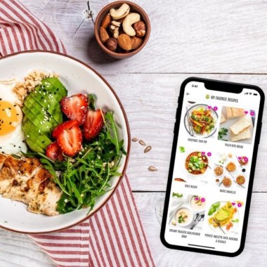 Wholesome Yum app with favorites view next to dish with chicken and salad.