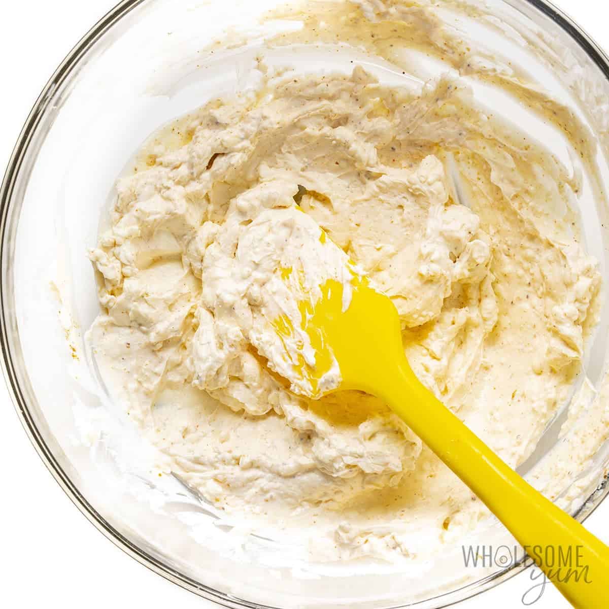 Cream cheese, sour cream, mayonnaise, lemon juice, and Old Bay seasoning mixed in a bowl.