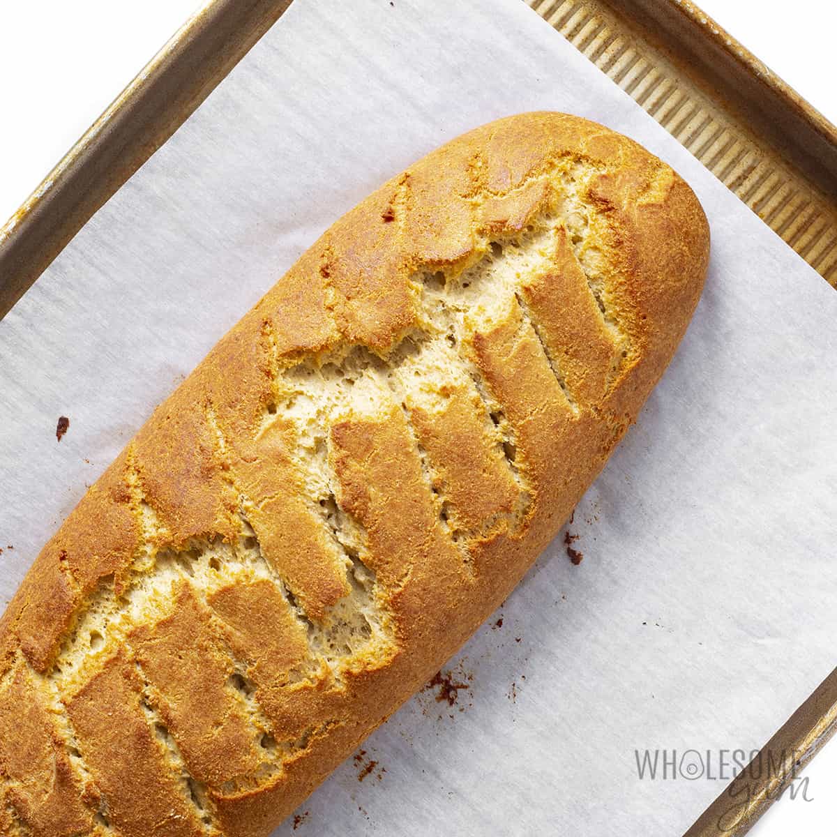 Baked bread loaf on a baking pan.