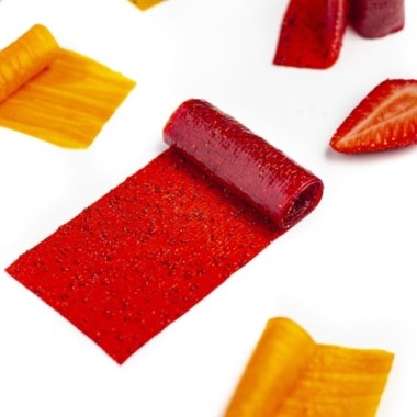 Assorted flavors of homemade fruit leather partially rolled.
