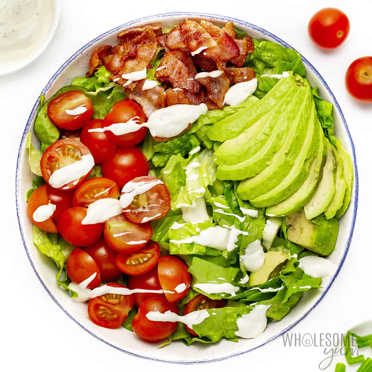 Bacon, lettuce, tomatoes, and avocado with dressing on top.