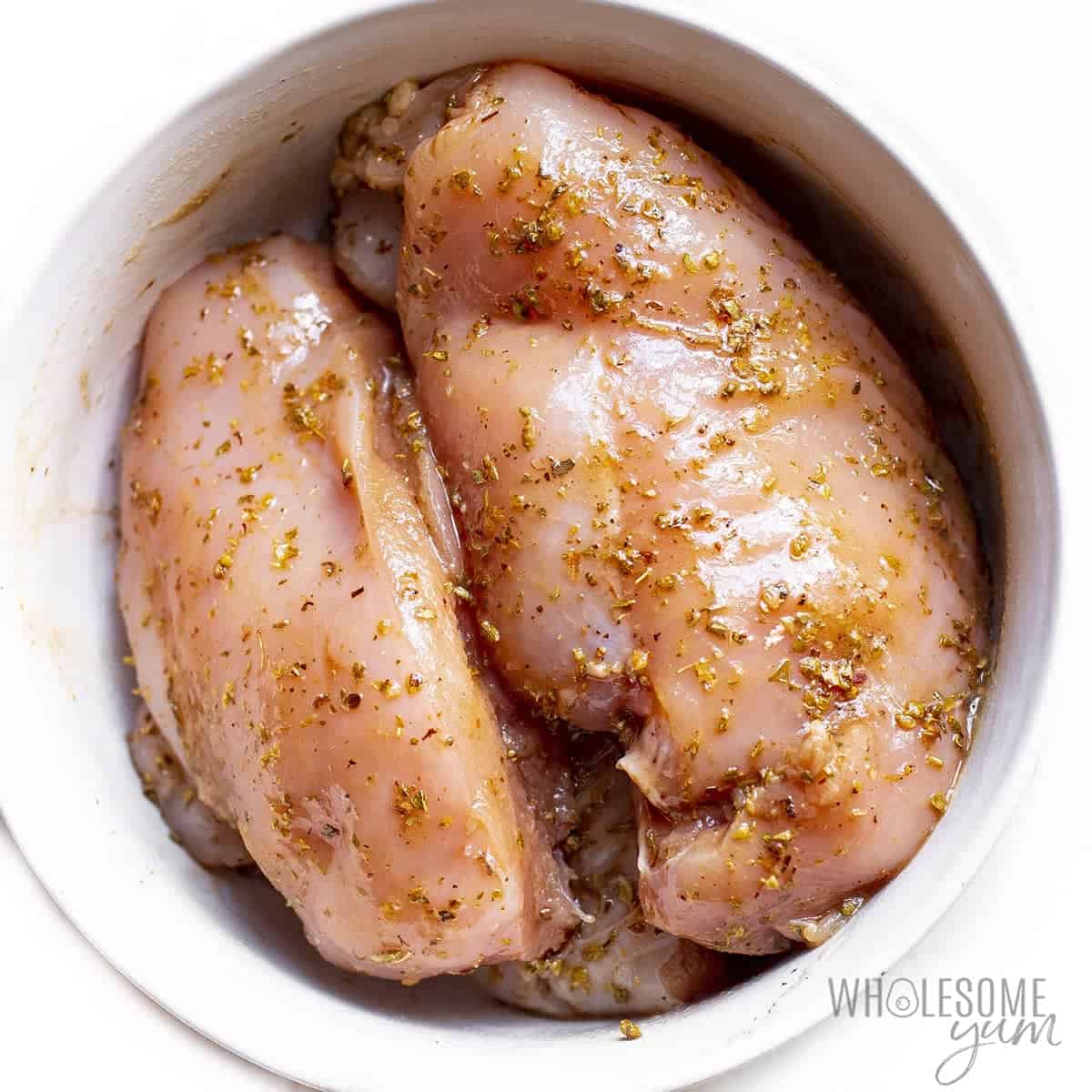 Chicken marinating in a bowl.