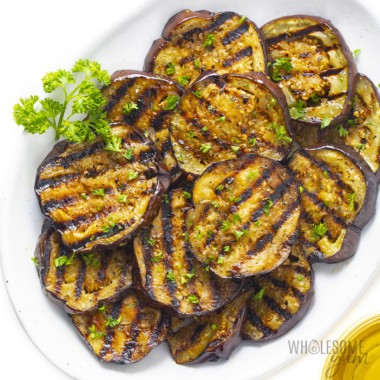 Grilled eggplant served on a white plate.