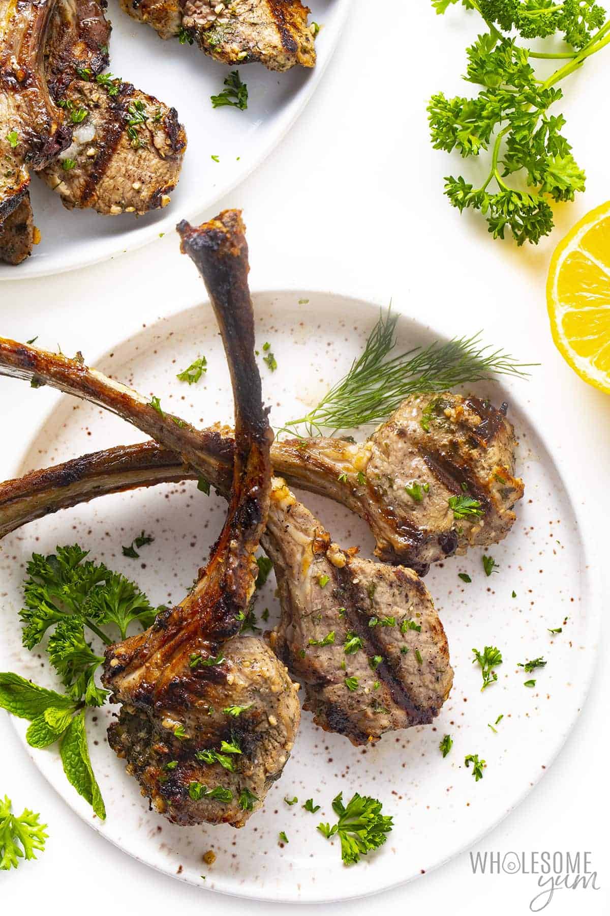 Rested grilled lamb chops on a plate.