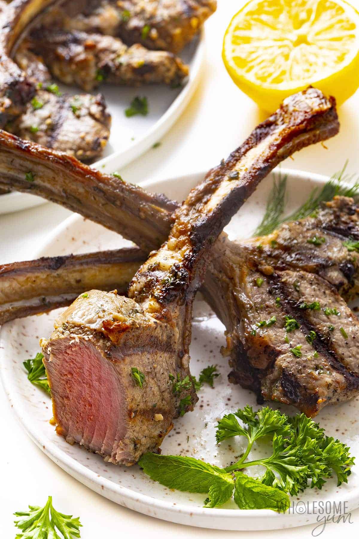 Plated lamb chops with one chop sliced.