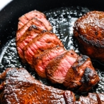 Sirloin steak in skillet.