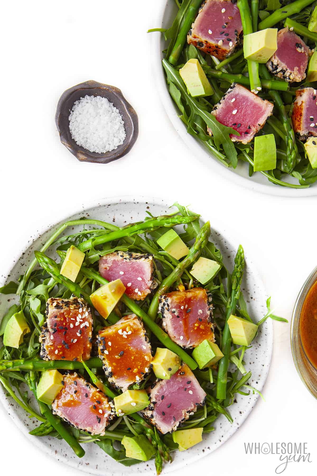 Plates of ahi tuna on salad.