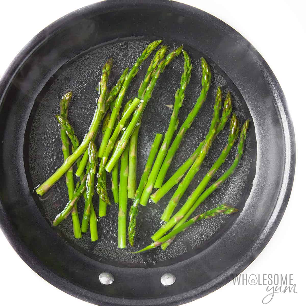 Asparagus cooking in pan.