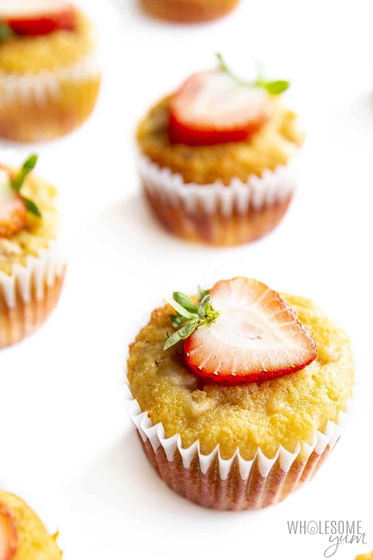 Close up of keto strawberry muffins with halved strawberries on top.