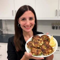 Maya with a plate of crab cakes.