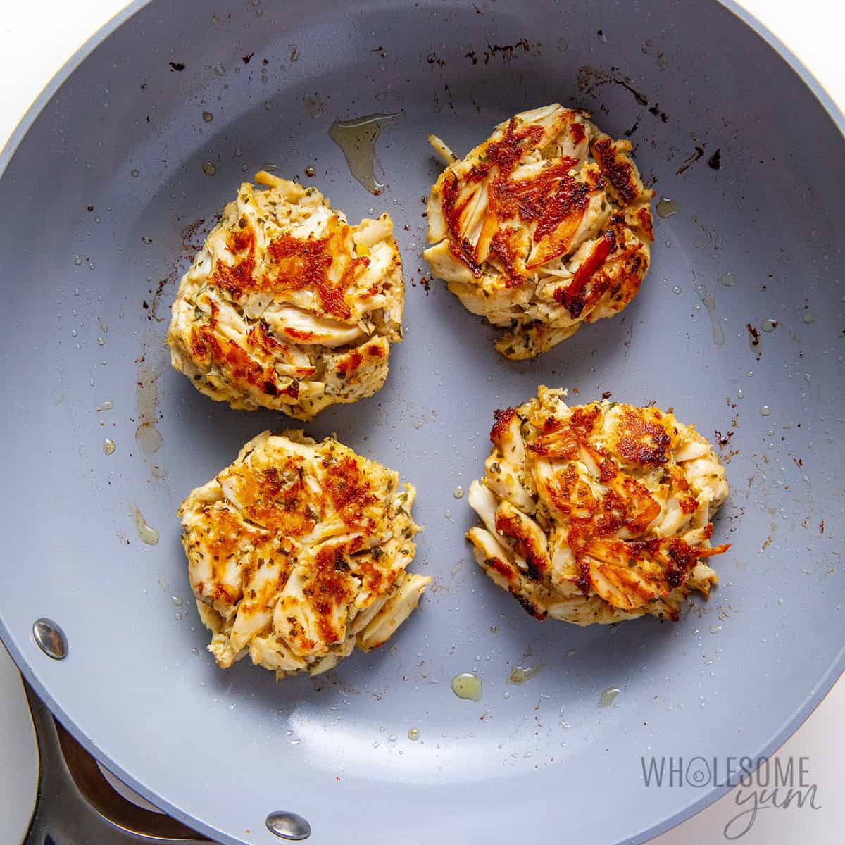 Frying the crab cake recipe in a skillet.
