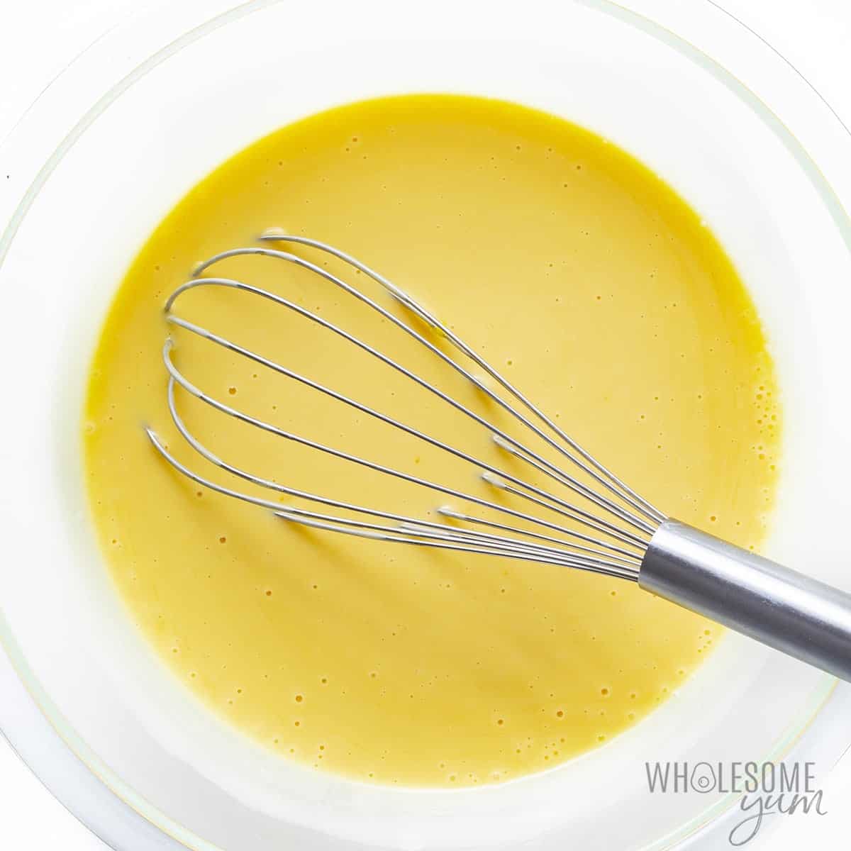 Whisked eggs and condensed milk in a bowl.