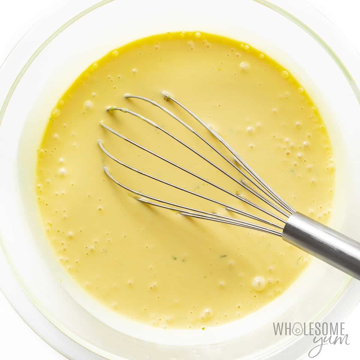 Sugar-free key lime pie filling in a bowl with whisk.