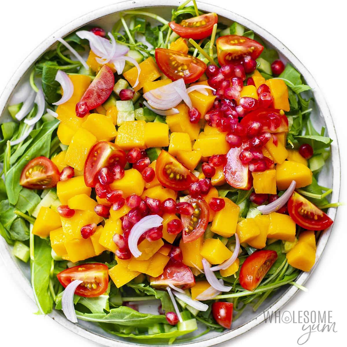 Greens with cucumber, mango, tomatoes, pomegranate, and onions.