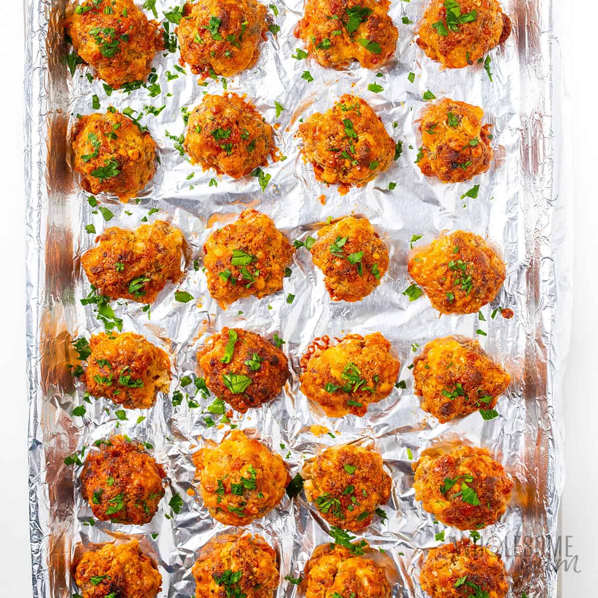 Baked sausage balls recipe on a baking sheet.