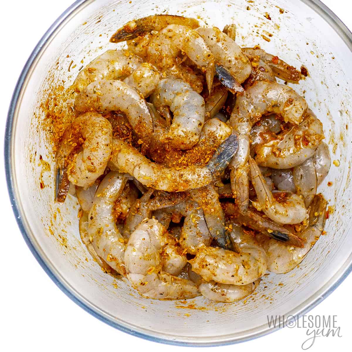 Seasoned shrimp in a glass bowl.