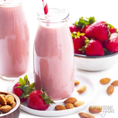 Side view of strawberry almond milk in glass bottle.