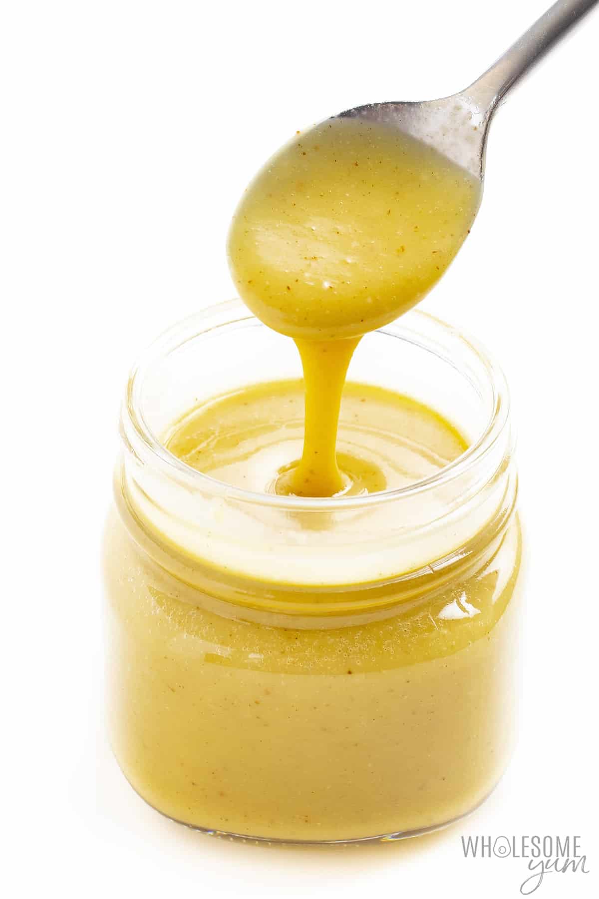 Sugar-free honey mustard in jar with spoon.
