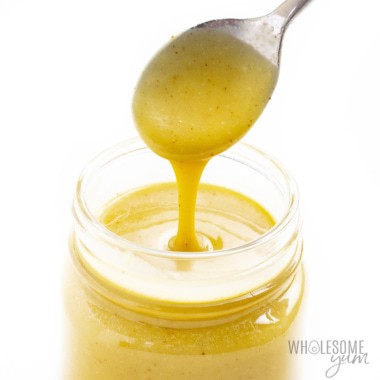 Jar of keto honey mustard with spoon dipped in.