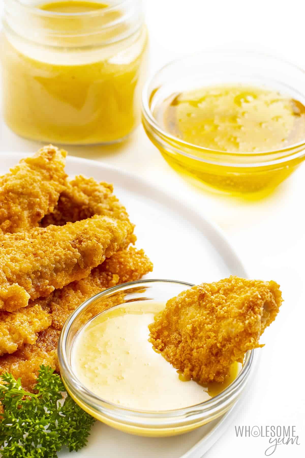 Sugar-free honey mustard plated with chicken strips.
