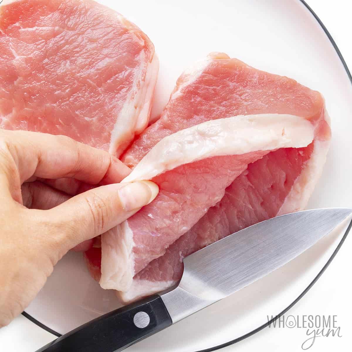 Pork chop with knife creating a pocket.