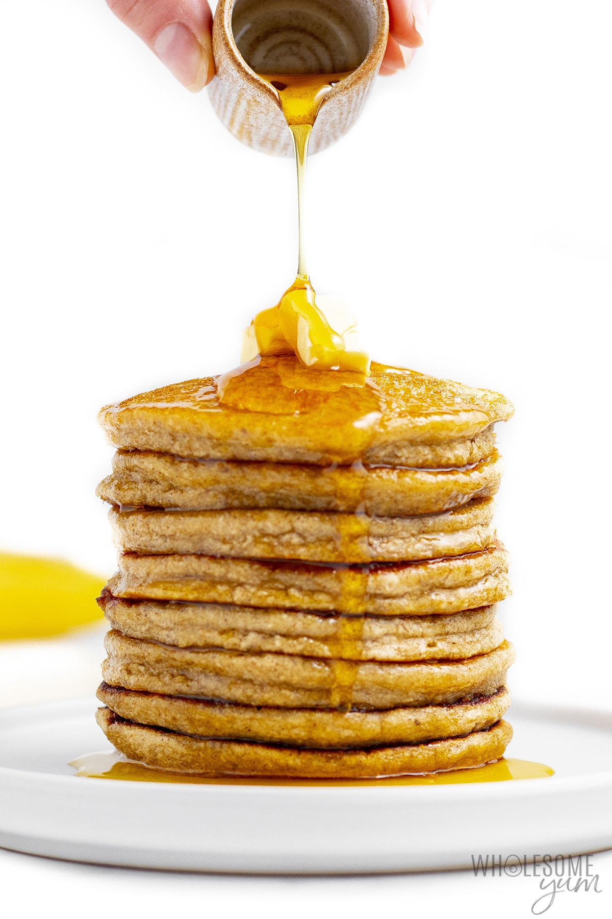 Stack of oat banana pancakes with syrup pouring over the top.