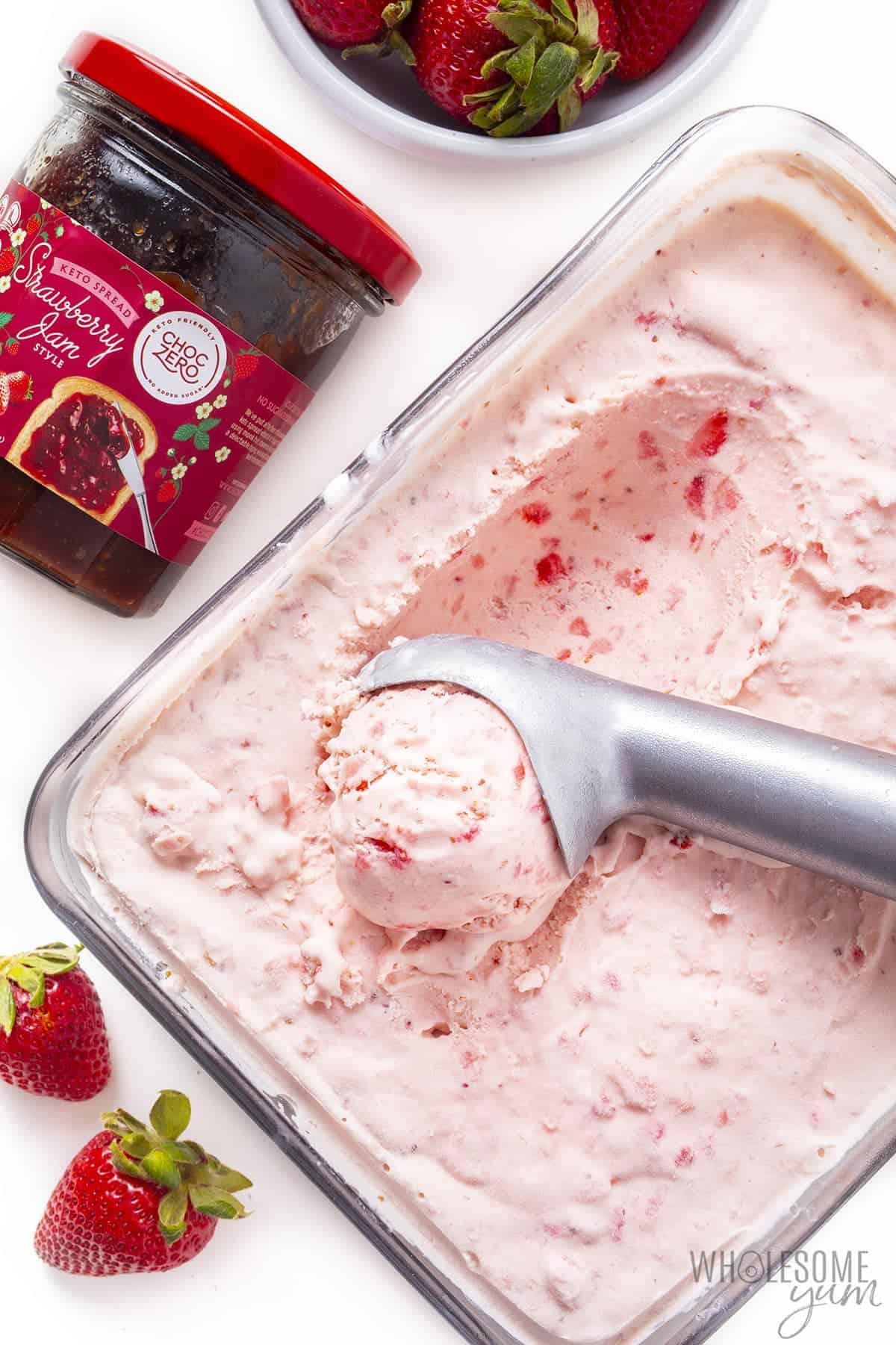 Keto strawberry ice cream next to jar of ChocZero strawberry jam.