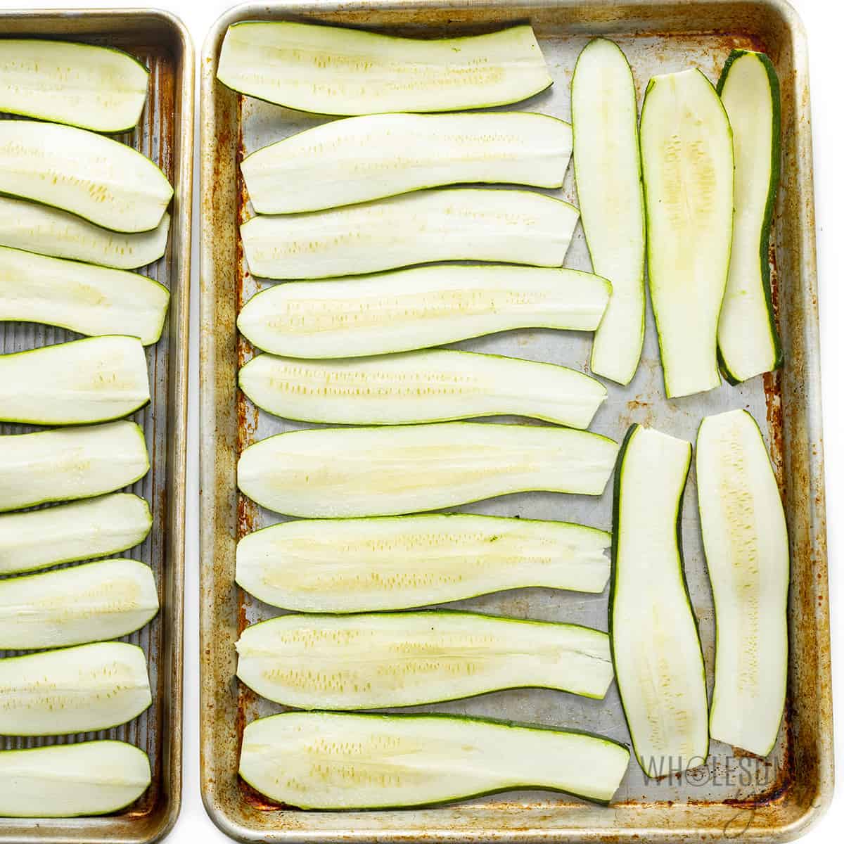 The zucchini strips are placed on the baking sheet.