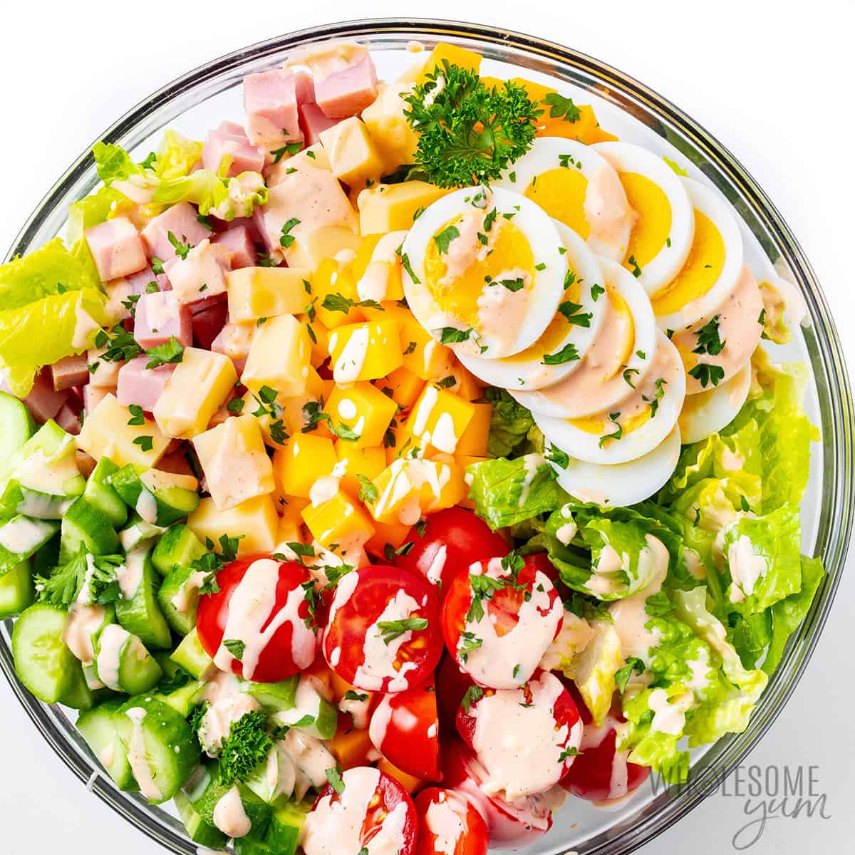 Finished chef salad recipe drizzled with dressing.