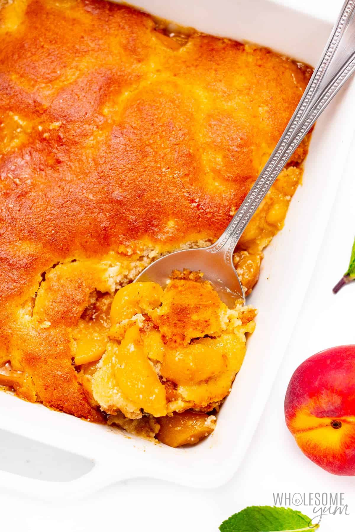 Baked low carb peach cobbler with spoon.