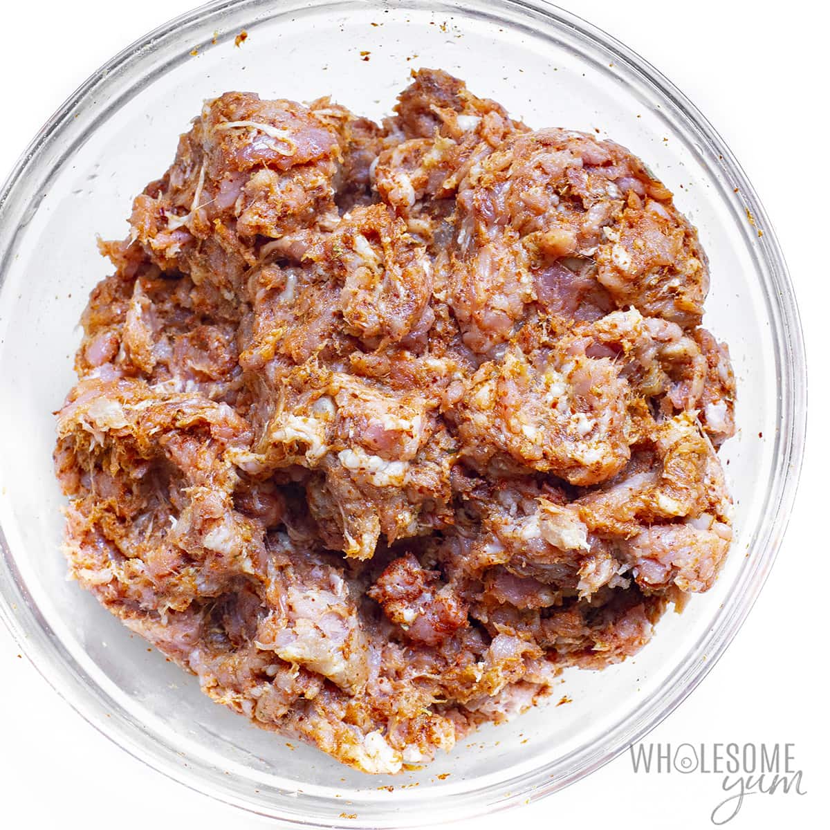 Spices mixed with meat in a bowl.