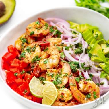 Shrimp avocado salad recipe in serving bowl with lime slices.