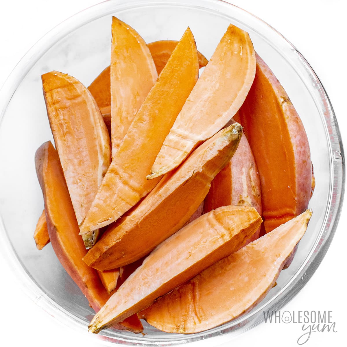 Raw sweet potato wedges in a bowl.