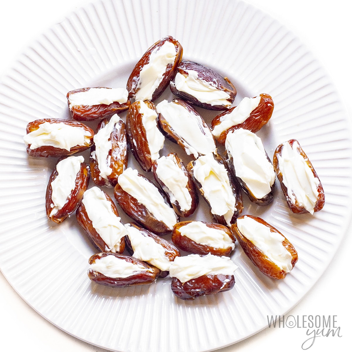 Dates stuffed with goat cheese on a plate.