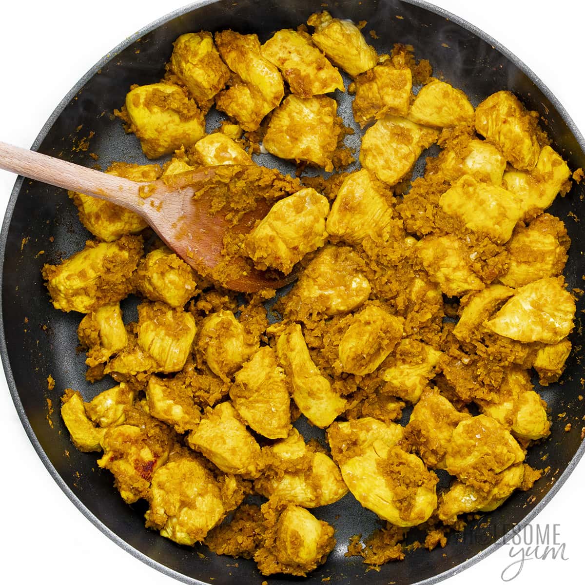 Spice paste with chicken in skillet.